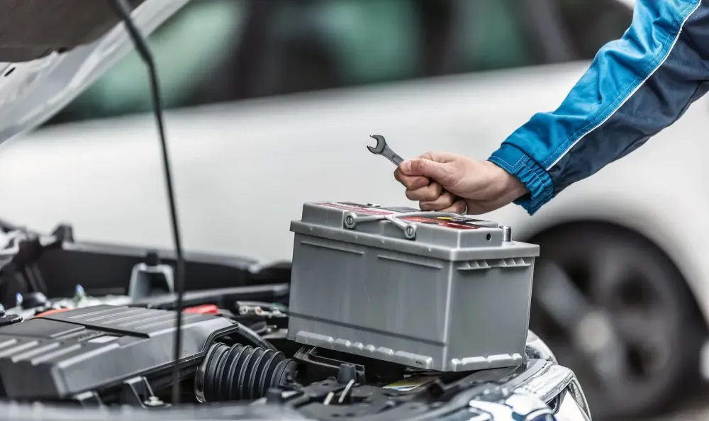 main+posée+sur+la+batterie+d-une+voiture